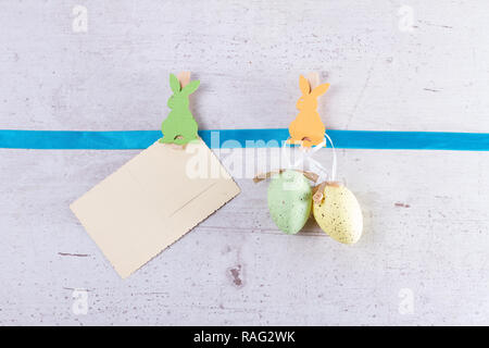 Easter scene with colored eggs and bunny pin with copy space on hanging paper note Stock Photo