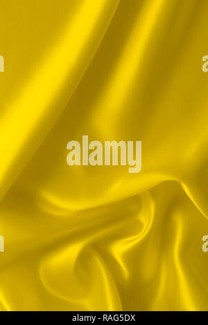 Smooth elegant yellow silver silk or satin luxury cloth fabric texture, abstract background design, banner or gift card. Stock Photo