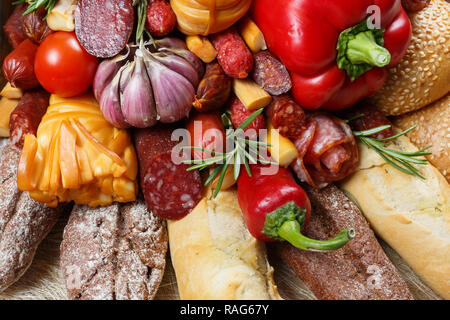 Edible gift to the man, consisting of different varieties of sausage, smoked cheeses, pepper, paprika, tomatoes and black bread. Close-up Stock Photo