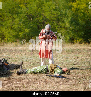 Historical festival Sambek Heights. Mujahid on the battlefield among dead Soviet soldiers Stock Photo