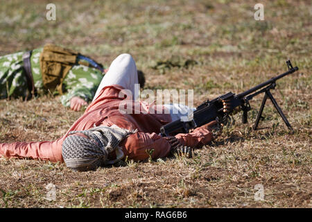 Historical festival Sambek Heights. Killed mojahed with the machine gun lies on the battlefield Stock Photo