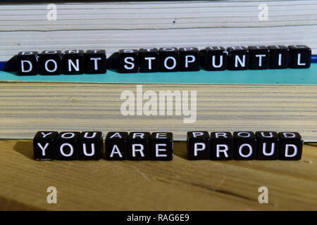 Don't stop until you're proud on wooden blocks. Motivation and inspiration concept. Cross processed image Stock Photo