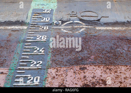 Load line marking and draft scale on the rusty hull of the ship in dry docking during repairs Stock Photo