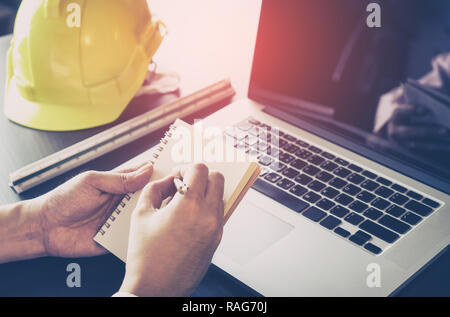 Engineer is making plan on blank notebook in office Stock Photo