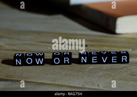 Now or never on wooden blocks. Motivation and inspiration concept. Cross processed image Stock Photo