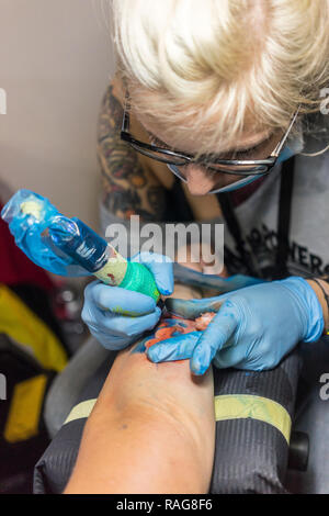 Tattooing artists at work - Tattoo conventions and exhibition in La Spezia, Lucca and Pistoia Stock Photo