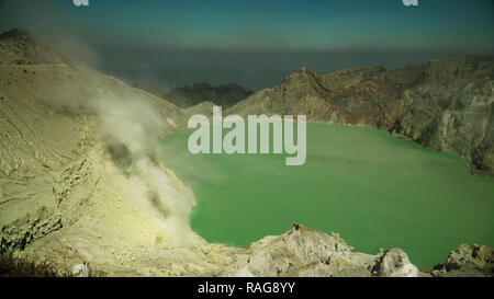 crater acid lake Kawah Ijen where sulfur is mined. Sulfur gas, smoke. mountain landscape Ijen volcano complex group of stratovolcanoes in East Java Indonesia Stock Photo