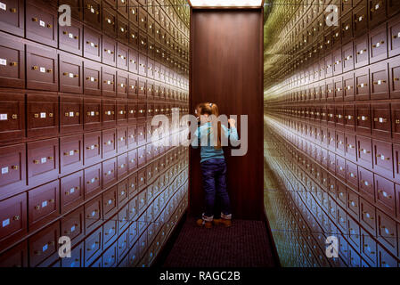 Mirror room illusions.A little girl stands in the room of illusions. The safe room is a multi-colored room of illusions. A room of illusions. Mirror r Stock Photo