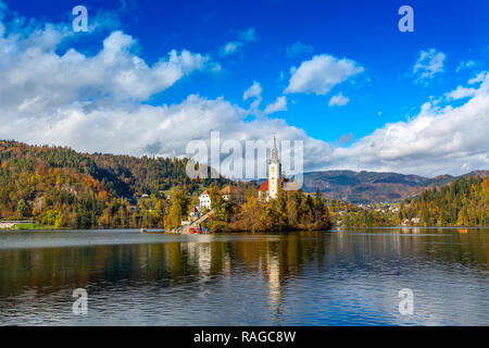 Panoramic view of Lake Bled with Church and Pletna boat, Slovenia and autumn colorful trees background Stock Photo