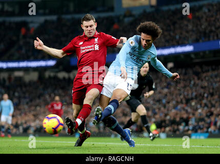 Liverpool's James Milner (left) and Manchester City's Leroy Sane (right) battle for the ball during the Premier League match at the Etihad Stadium, Manchester. Stock Photo