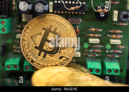 Bitcoin gold coin on computer circuit board microchips. Electronic cryptocurrency. Stock Photo
