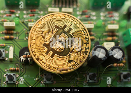 Bitcoin gold coin on computer circuit board microchips. Electronic cryptocurrency. Stock Photo