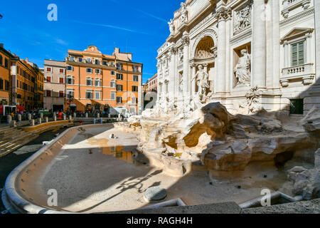 An art historian cleans and maintains the empty, drained Trevi Fountain on a sunny afternoon in early autumn in Rome, Italy Stock Photo