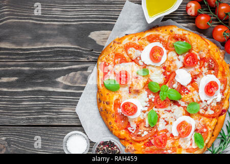 Margherita Italian pizza with melted mozzarella cheese, tomato and fresh basil on rustic wooden table. top view with copy space Stock Photo