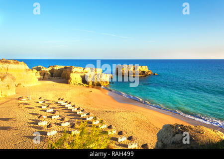 beautiful sandy beach among rocks and cliffs with sunbeds near Albufeira in Algarve, Portugal. Stock Photo