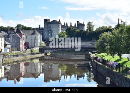 View of calm river Nore with bridge and stone Kilkenny Castle in background. Stock Photo