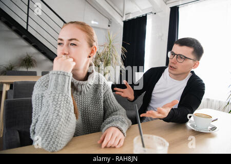 Couple fighting. A young man is trying to have a conversation, while he's been ignored by his girlfriend Stock Photo