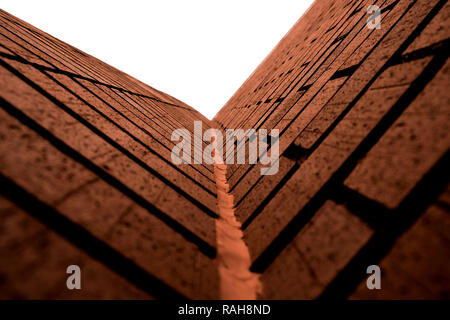 Brick walls at a corner looking up; detail and vanishing focal point. Stock Photo