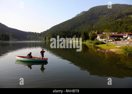 Young fishermen in a rowing boat on lake Spitzingsee, a mountain lake, 1084 meters above sea level, Mangfall mountains Stock Photo