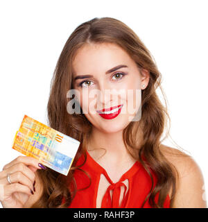 Young happy brunette woman holds a 10 Swiss francs, isolated on white background. Suisse francs bank note. Suisse franc is the national currency of Sw Stock Photo