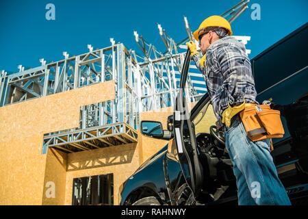 Caucasian Construction Site Worker in Front of His Pickup Truck. Stock Photo