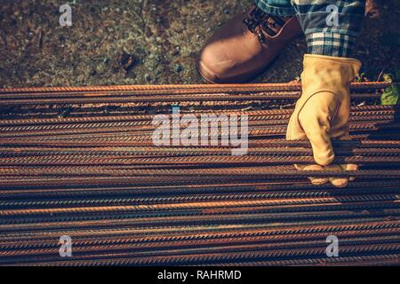 Contractors Hands on the Steel Elements. Steel Reinforcement Bars. Construction Industry. Stock Photo