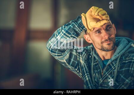 Tired by Happy Caucasian Worker in His 30s. Construction Industry. Stock Photo
