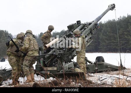 U.S. Paratroopers assigned to the 4th Battalion, 319th Airborne Field Artillery Regiment, fire precision guided munitions from M777 Howitzers while conducting Artillery Gunnery Table XVIII at the 7th Army Training Command’s Grafenwoehr Training Area, Germany, Feb. 3, 2017. The Exercise trains and evaluates the Battalion's ability to mass fires in direct support of the 173rd Airborne Brigade.  Evaluators from the 82nd DIVARTY, assist the battalion by objectively reviewing its timeliness and accuracy of massed fires while firing in support of a heavy weapons company defensive live fire exercise. Stock Photo