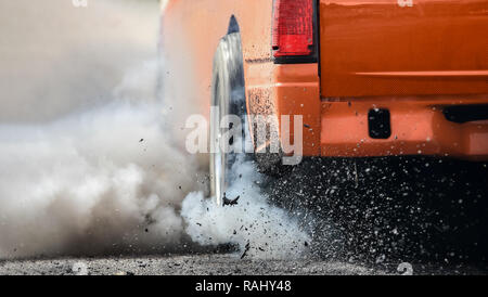 Drag racing car burns rubber off its tires in preparation for the race Stock Photo