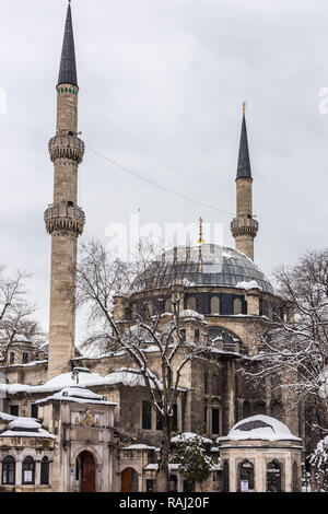 Eyup Sultan Mosque in winter in the snow. The mosque is situated in the Eyup district of Istanbul, outside the city walls near the Golden Horn. Stock Photo