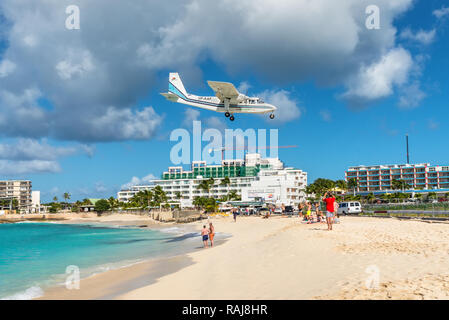 Simpson bay, Saint Maarten - December 17, 2018: The Britten-Norman BN-2B-21 Islander airplane fly over beachgoers in Saint Martin, Dutch Antilles, Car Stock Photo