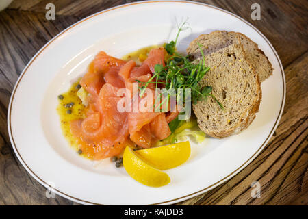 Smoked salmon served with wholegrain bread and wedges of lemon. The salmon is Scottish.