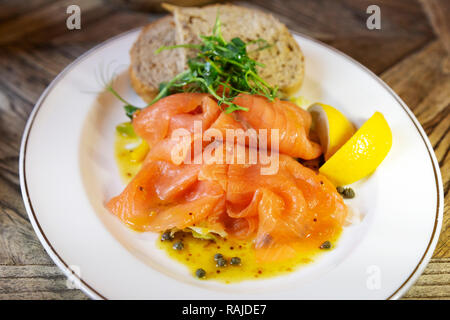 Smoked salmon served with wholegrain bread and wedges of lemon. The salmon is Scottish.