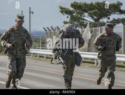 Torii Station, Okinawa (Feb 12, 2017) –Sgt. Maj. Juan Rosario-Montalvo (left) and Sgt. Maj. Michael Barcena motivate soldiers crossing the finish line of the 12-mile ruck march during the US Army Japans best warrior competition. The top competitors of this competition will continue on to compete in a pacific-wide competition in Hawaii. Stock Photo