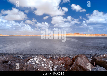Marshy Inlets An inlet at low tide revealing marshy ground with lava rocks under a ...