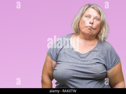 Senior plus size caucasian woman over isolated background making fish face with lips, crazy and comical gesture. Funny expression. Stock Photo