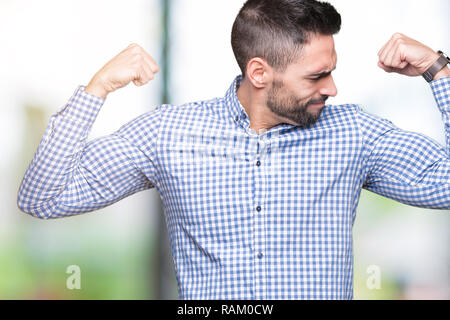 Young handsome man over isolated background showing arms muscles smiling proud. Fitness concept. Stock Photo