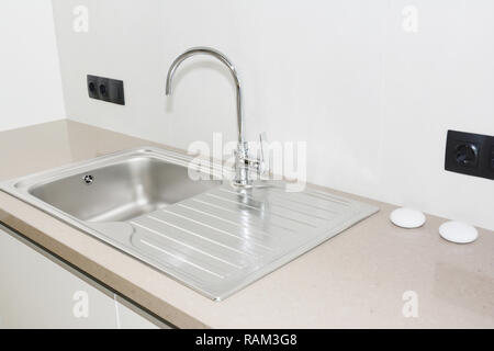 Metal kitchen sink. Modern kitchen metal faucet and  metal kitchen sink. Stock Photo