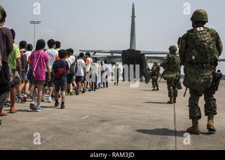 Japan Self-Defense Force (JSDF) service members escort  Japanese citizens onto a JSDF C-130 aircraft during a noncombatant evacuation operation exercise during Cobra Gold 2017 at Utapao International Airport in Rayong Province, Thailand, Feb. 19, 2017. Cobra Gold, in its 36th iteration, focuses on humanitarian civic action, community engagement,  and medical activities to support the needs and humanitarian interest of civilian populations around the region. Stock Photo