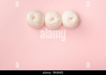 top view of white knitting clews on pink tabletop Stock Photo