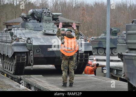 German soldiers with the 122nd Mechanized Infantry Battalion, 12th Armored Brigade, 10. Panzer Division, load tracked Marder infantry fighting vehicles onto railroad carts at the 7th Army Training Command’s Grafenwoehr Tower Barracks railhead station, Germany, Feb. 21, 2017. The unit deploys to the Baltics as part of NATO's Enhanced Forward Presence. Stock Photo