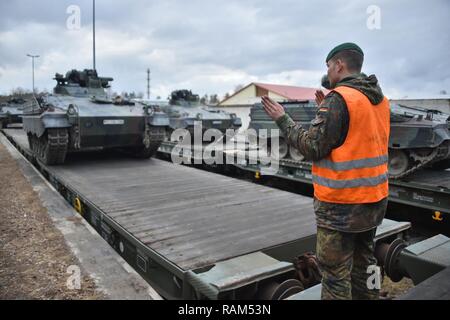 German soldiers with the 122nd Mechanized Infantry Battalion, 12th Armored Brigade, 10. Panzer Division, load tracked Marder infantry fighting vehicles onto railroad carts at the 7th Army Training Command’s Grafenwoehr Tower Barracks railhead station, Germany, Feb. 21, 2017. The unit deploys to the Baltics as part of NATO's Enhanced Forward Presence. Stock Photo