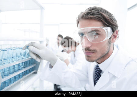 man in goggles to check fluid in vitro. Stock Photo