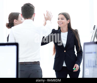 employees giving each other high five. Stock Photo