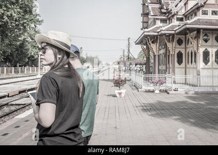 Young couple is waiting for the train in train station of Hua Hin, Thailand Stock Photo