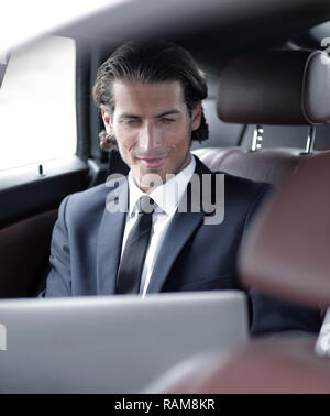 man working on laptop while sitting in the car Stock Photo