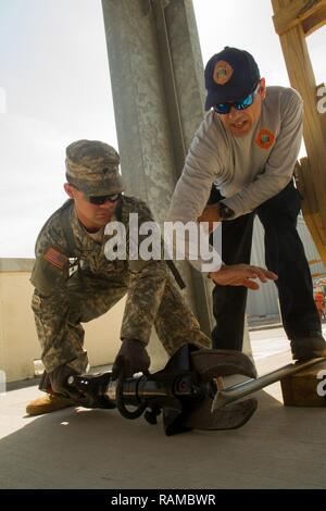 Lt. Christopher Pecori, a flight medic with the Miami-Dade Fire Rescue Department (MDFR), assists Army Reserve Spc. Lewis Colon on how to operate cutters during training at the MDFR training facility on Feb. 17, 2017 in Doral, Fla. Colon is assigned to the 329th Chemical, Biological, Radiological, and Nuclear (CBRN) Company (Reconnaissance and Surveillance), based in Orlando, Fla. He is CBRN specialist from Tampa, Fla. The 329th CBRN Company, the Army Reserve’s 469th Ground Ambulance Company, from Wichita, Kan., and the Florida National Guard’s Civil Support Team, spent the day training with M Stock Photo