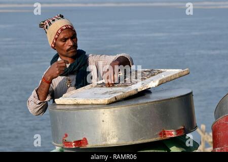 A fisherman bait a fish hook on the banks of Brahmaputra river to fish in Guwahati, Assam, India on Friday, January 4, 2019. PHOTO: DAVID TALUKDAR. Stock Photo