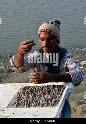 A fisherman bait a fish hook on the banks of Brahmaputra river to fish in Guwahati, Assam, India on Friday, January 4, 2019. PHOTO: DAVID TALUKDAR. Stock Photo