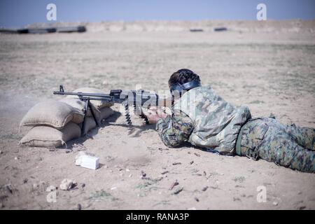 A local female Manbij Military Council trainee fires a 7.62mm PK machine gun during marksmanship training Feb. 21, 2017, at Sanaa Training Center in Northwest Syria. The instruction is 20 days long to include basic rifle marksmanship, and squad level weapons and movement techniques. This is the first cycle of women to graduate and join the MMC. The course is administered by Special Operations Joint Task Force – Operation Inherent Resolve trainers. Stock Photo